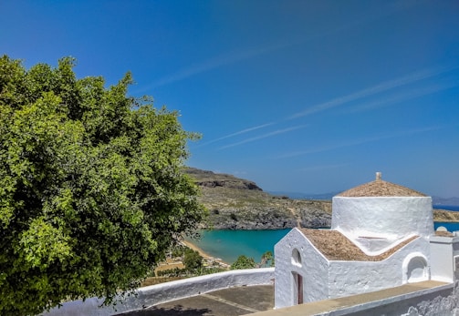 A serene coastal site with a geodesic dome structure nestled amidst rugged maritime landscape under a soft morning sky