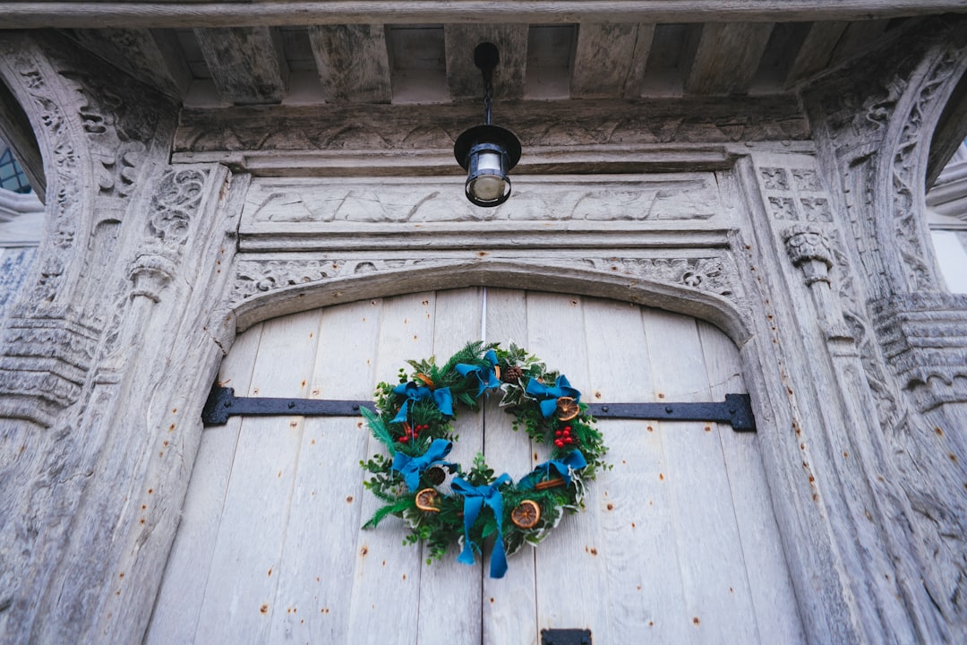 green red and yellow wreath on white wooden door