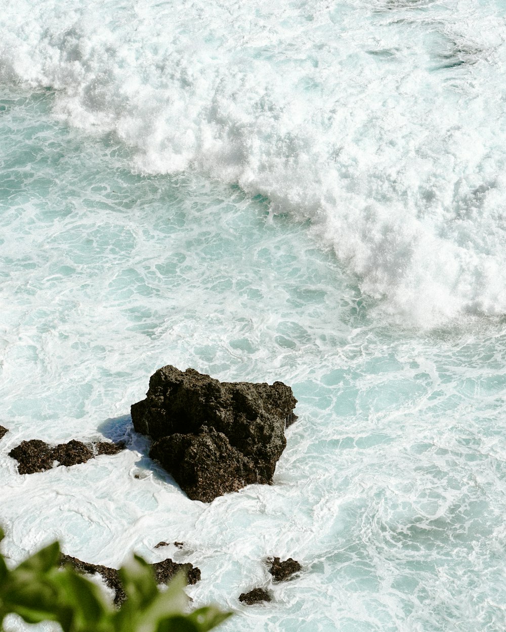 brown rock formation on body of water during daytime