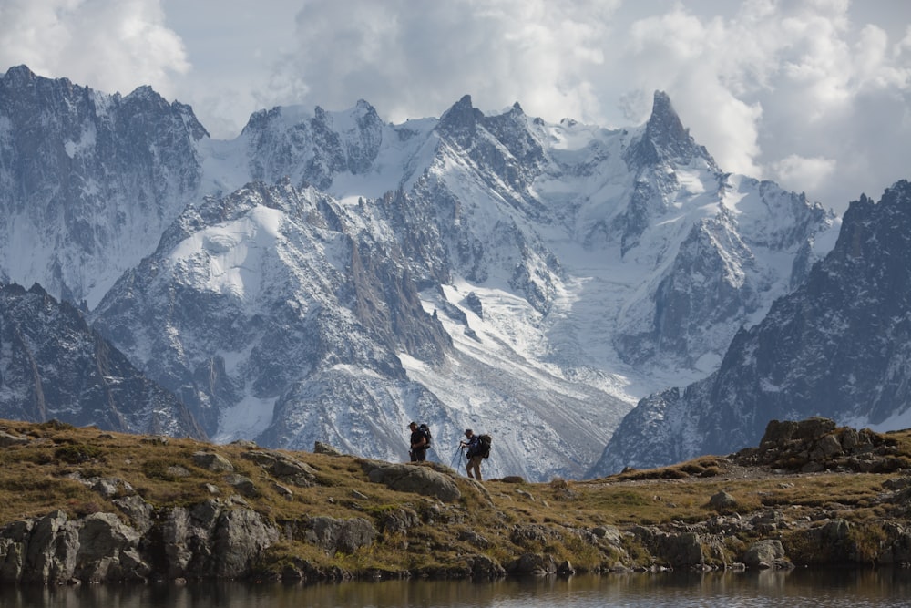 person standing on green grass field near snow covered mountain during daytime