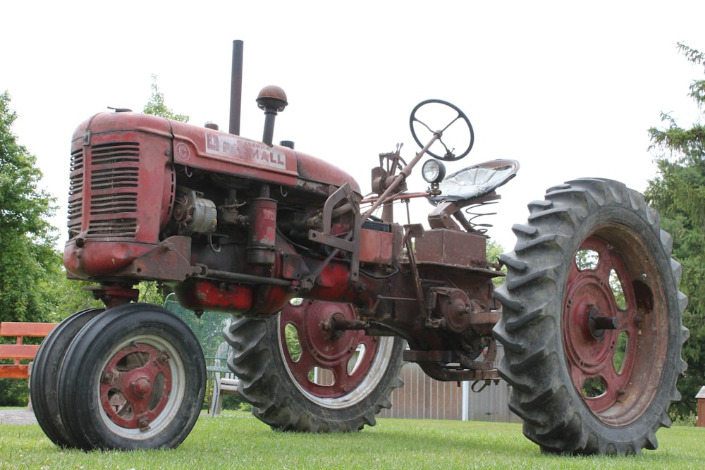 red tractor on green grass field during daytime