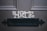 The word 'HOME' is painted in a decorative font on a dark wooden door above a black metal mail slot.