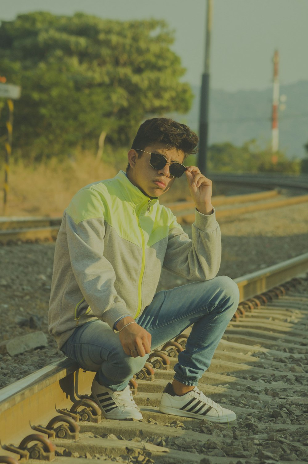 homme en chemise verte et jean bleu assis sur un rail de train pendant la  journée photo – Photo Chemin de fer Gratuite sur Unsplash