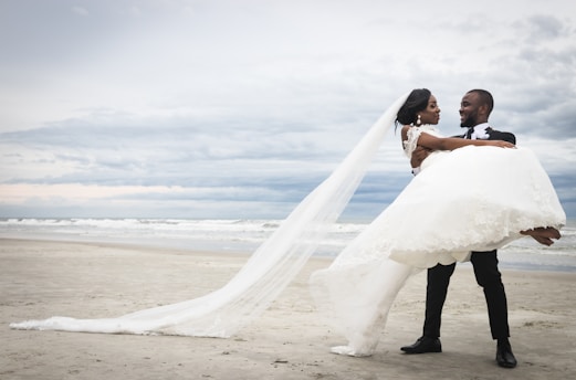 bride and groom kissing on beach after their wedding