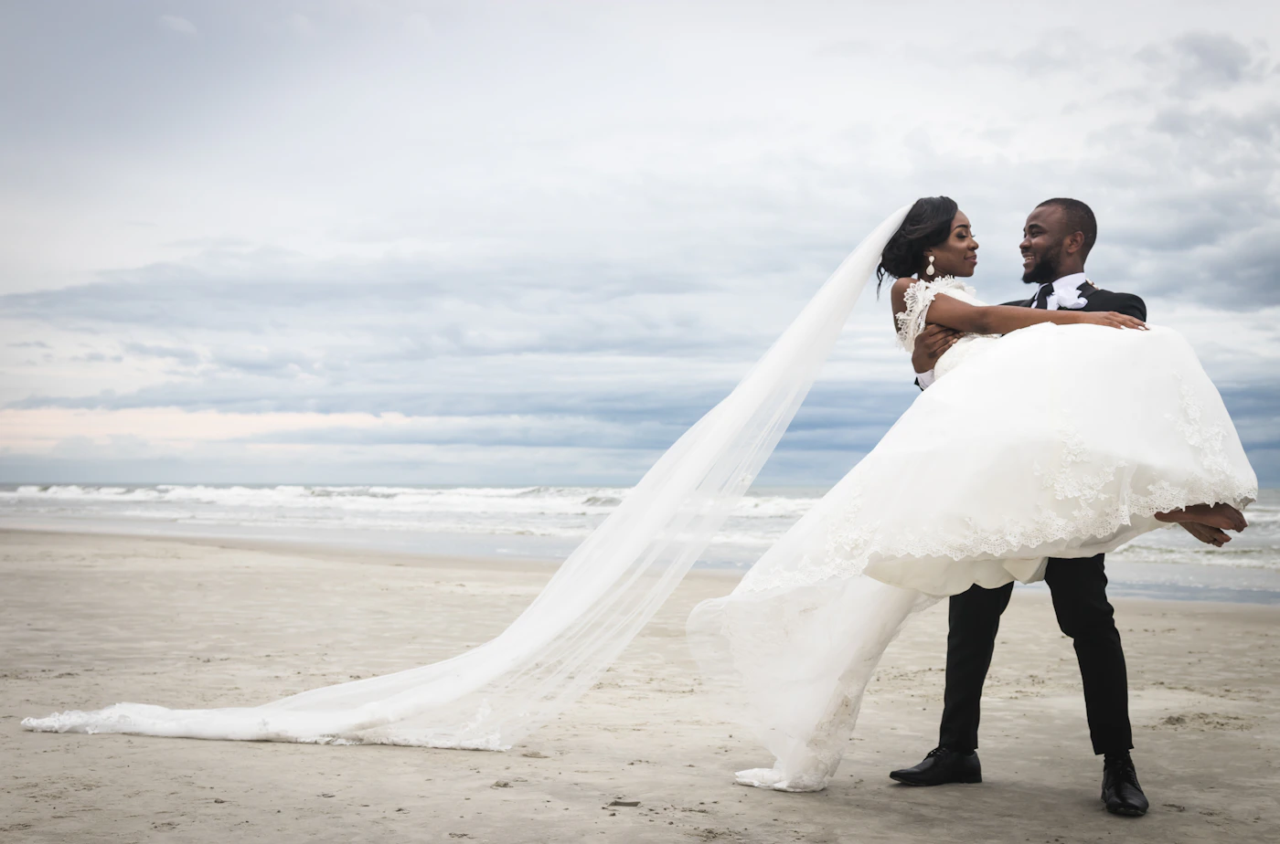 Bride and groom kissing together on a sunny beach
