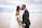 man in black suit kissing woman in white wedding dress on beach during daytime