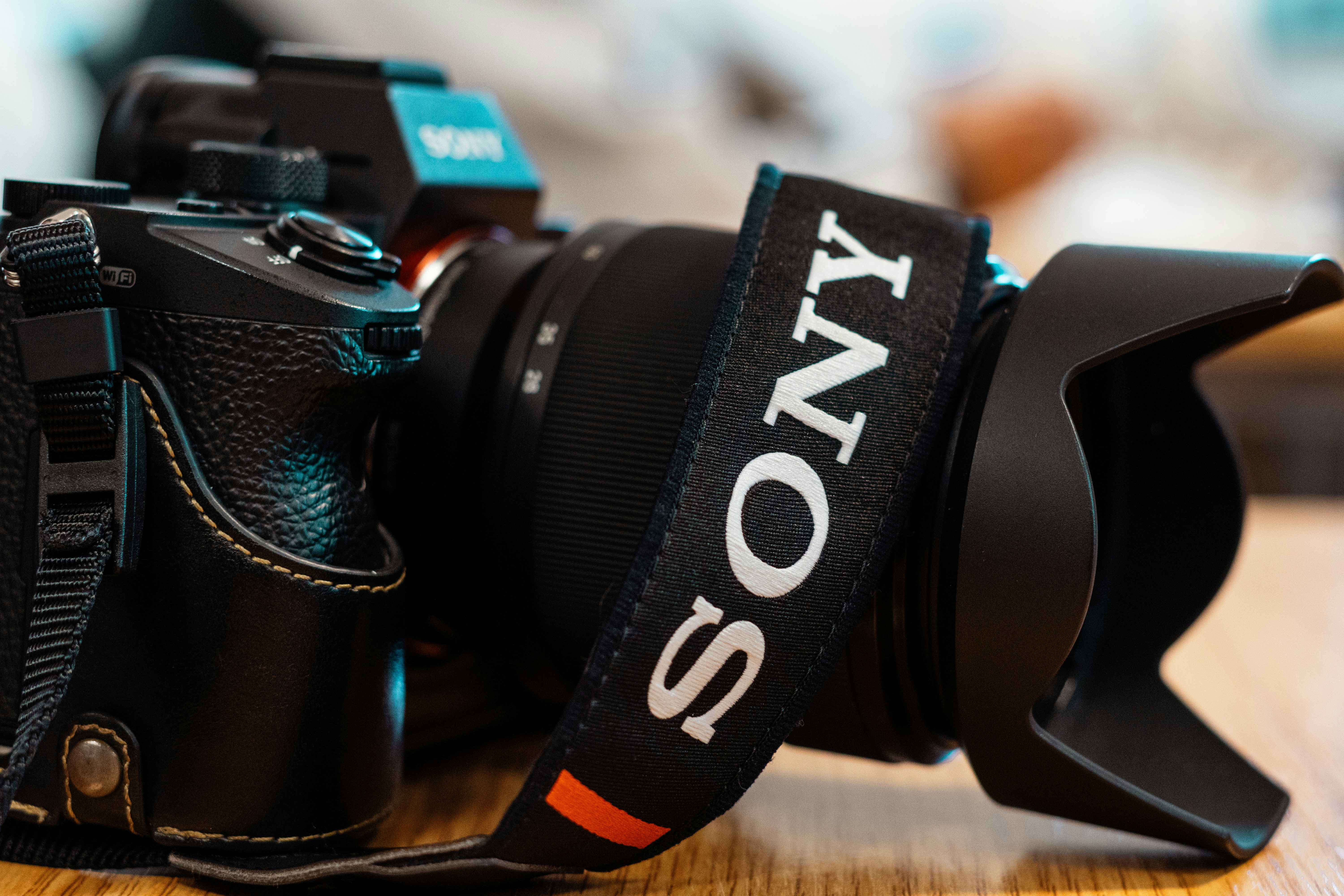 갈색 나무 테이블에 블랙 니콘 DSLR 카메라