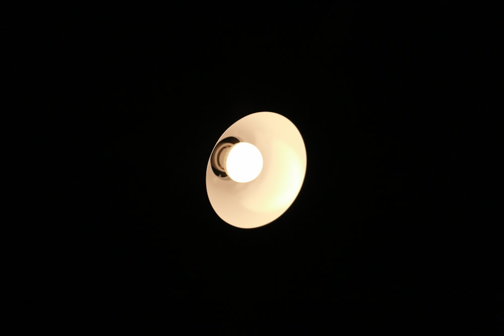 white light bulb turned on in dark room