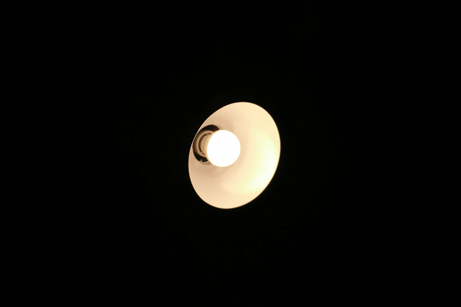 A single lit light bulb in a dark room, representing Google's own guidance clarifying what these terms actually require