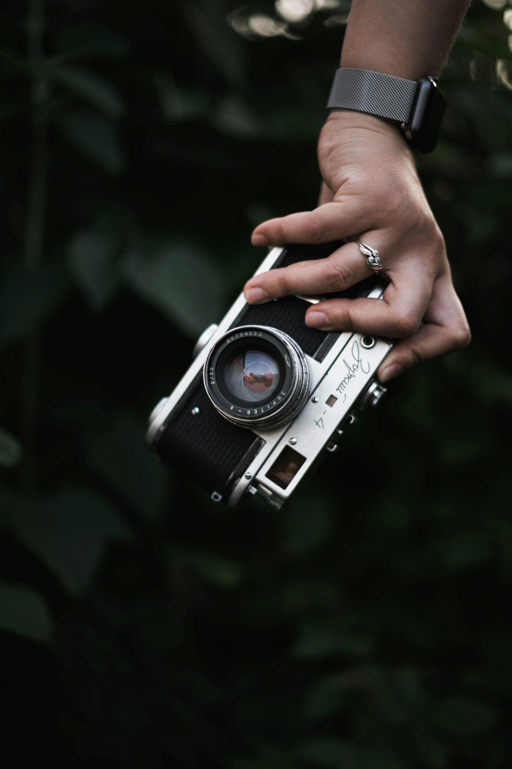 person holding silver and black camera