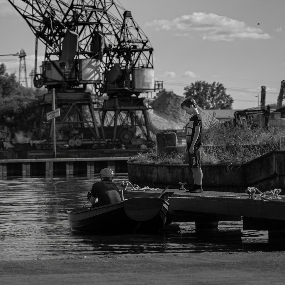 grayscale photo of man riding on boat