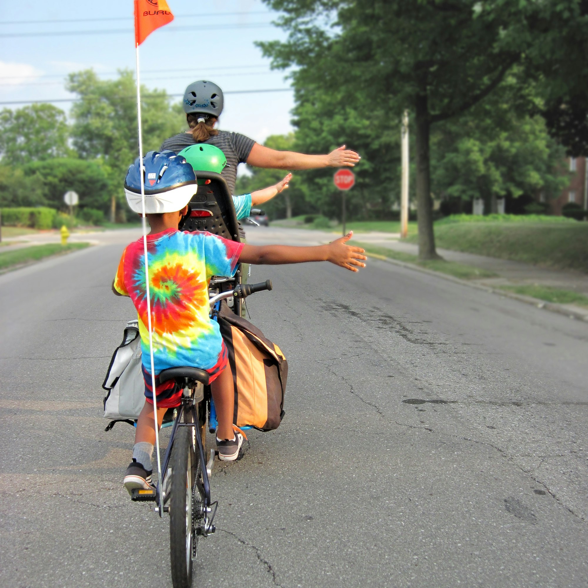 A woman cycling with two small children