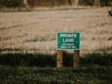 blue and white wooden signage on green grass field during daytime
