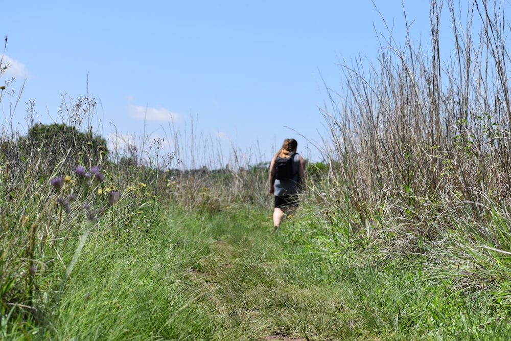 Mujer con camisa negra de pie en el campo de hierba verde durante el día