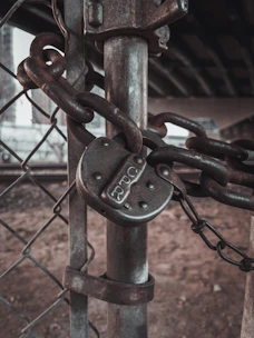 A close-up of a high-security chain lock wrapped around a gate, emphasizing toughness.