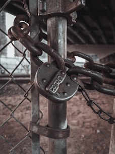 Mobile locksmith fixing a metal gate hinge in an urban residential area.