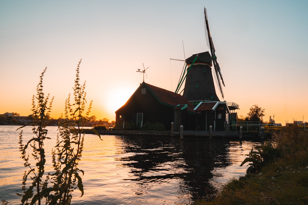 brown wooden house on water during sunset