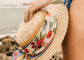 woman in blue and white floral bikini wearing brown sun hat