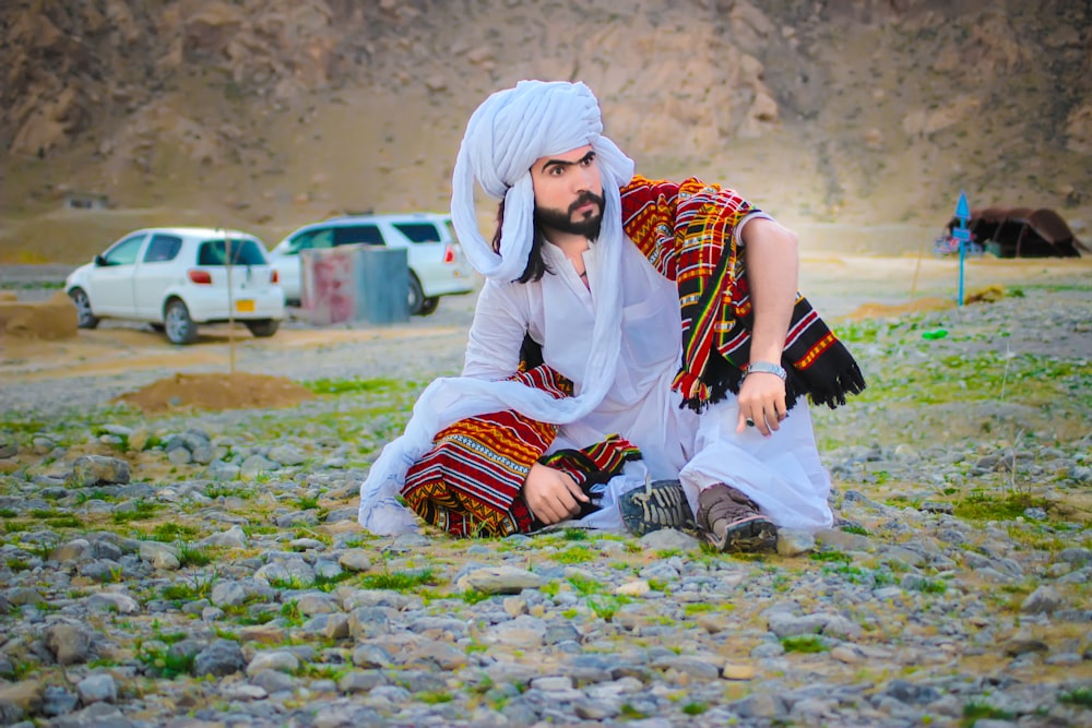 woman in white hijab sitting on ground during daytime