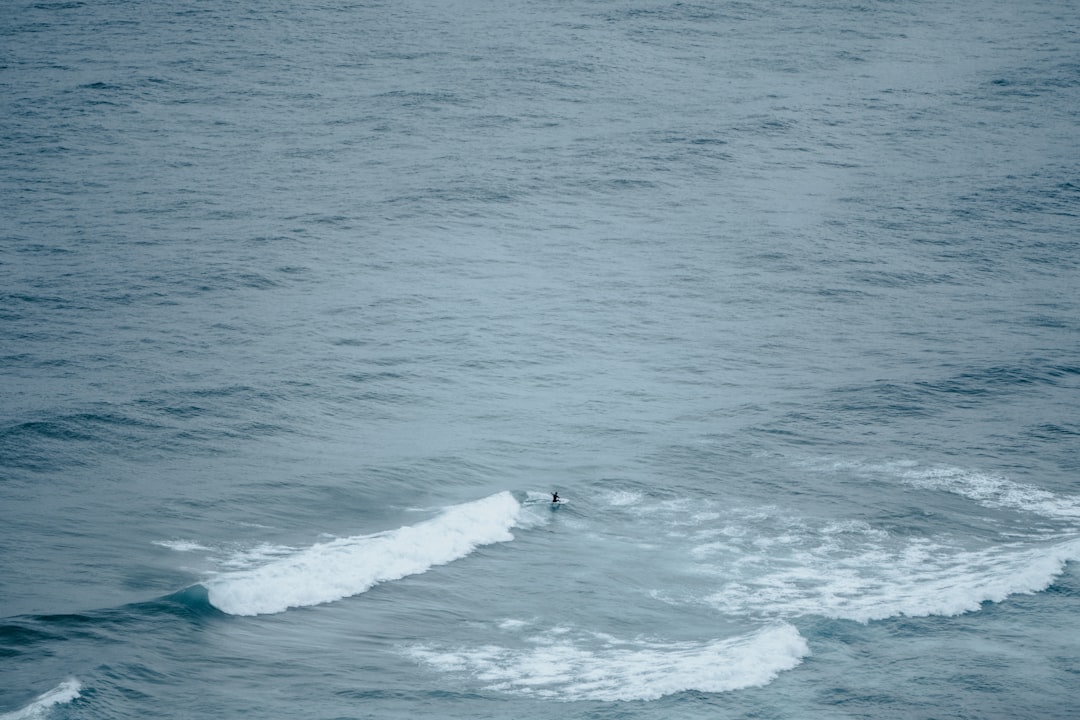 person surfing on sea waves during daytime