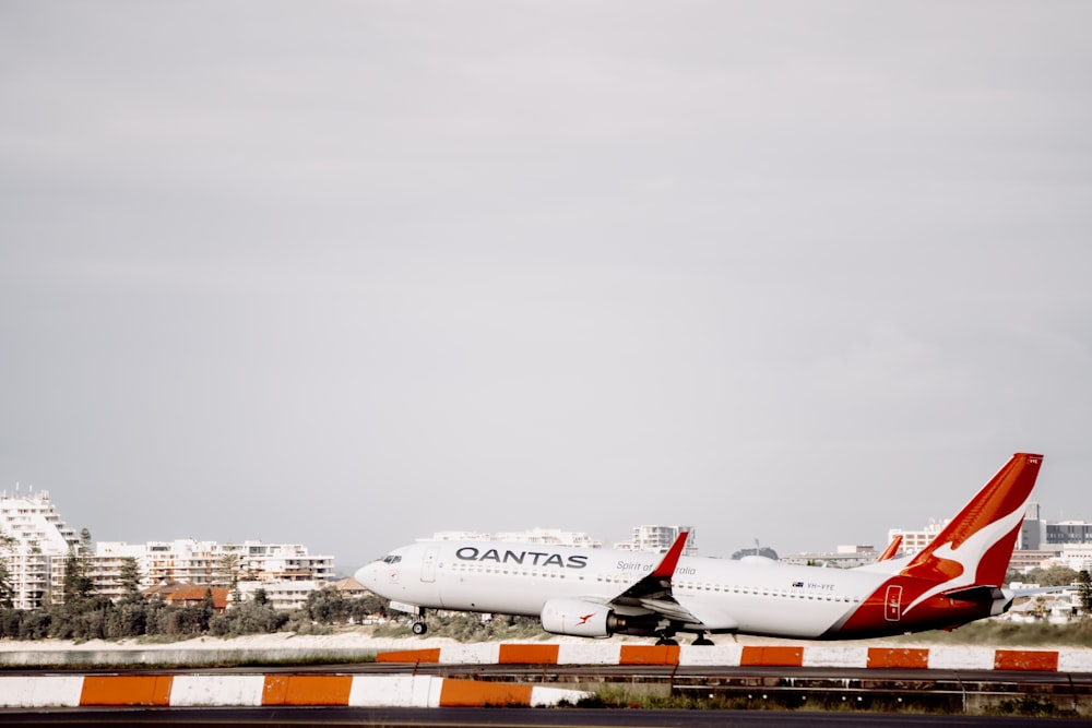 weißes und orangefarbenes Flugzeug tagsüber am Flughafen