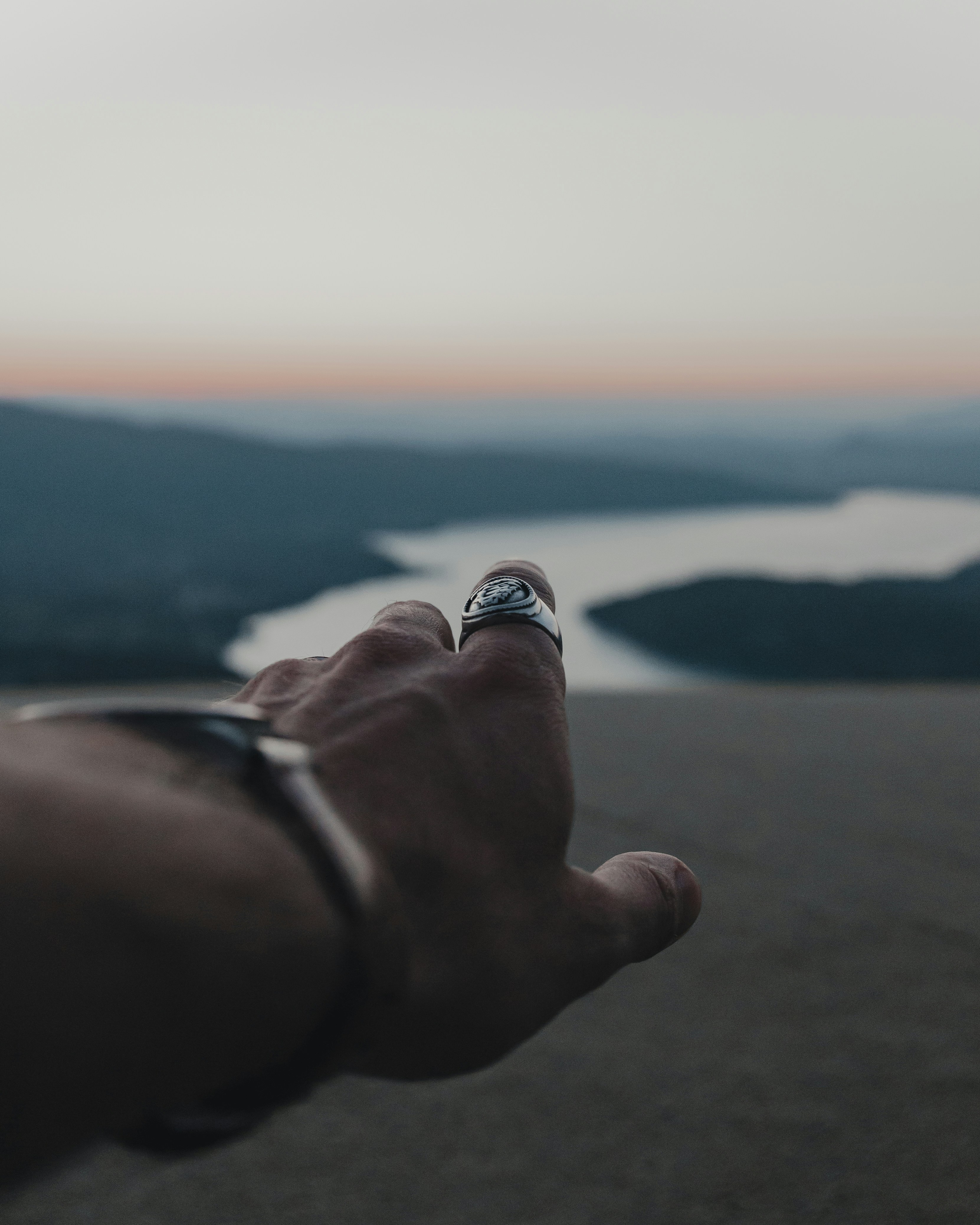 persona que lleva anillo de plata con anillo de piedra blanco y negro