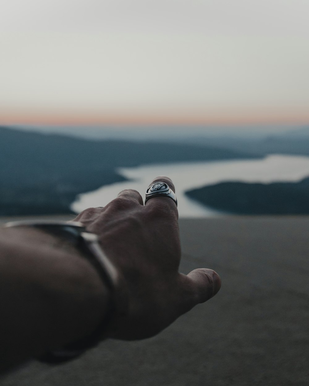 person wearing silver ring with black and white stone ring