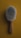 A close-up view of a wooden-handled brush with soft, dense bristles set against a mustard yellow background.