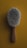A close-up view of a wooden-handled brush with soft, dense bristles set against a mustard yellow background.