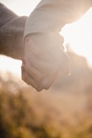 A smiling couple holding hands in a sunlit park, symbolizing trust and connection.