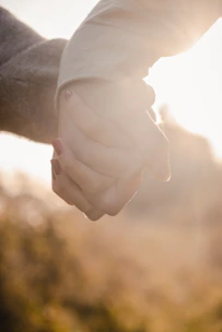 A couple holding hands during a sunrise prayer moment outdoors.