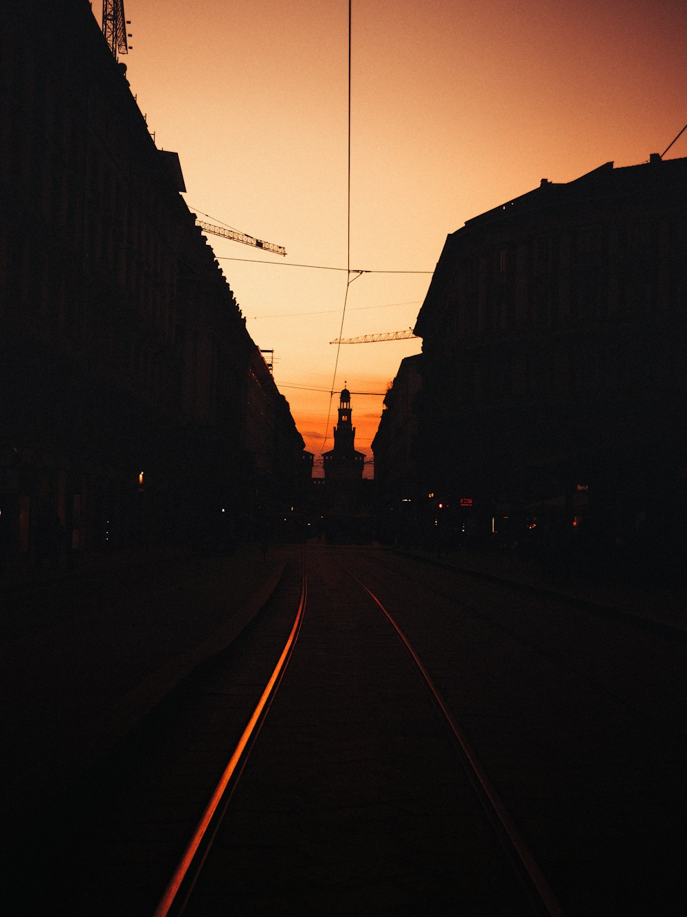 route asphaltée noire entre les bâtiments au coucher du soleil