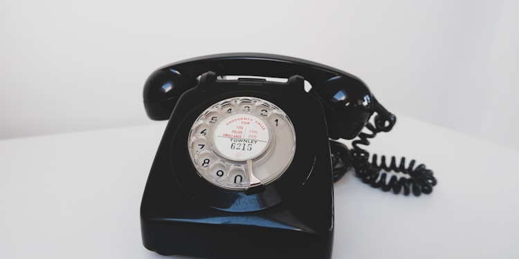 black rotary phone on white surface