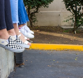 person in blue denim jeans and black and white sneakers