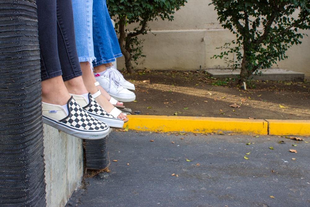 person in blue denim jeans and black and white sneakers