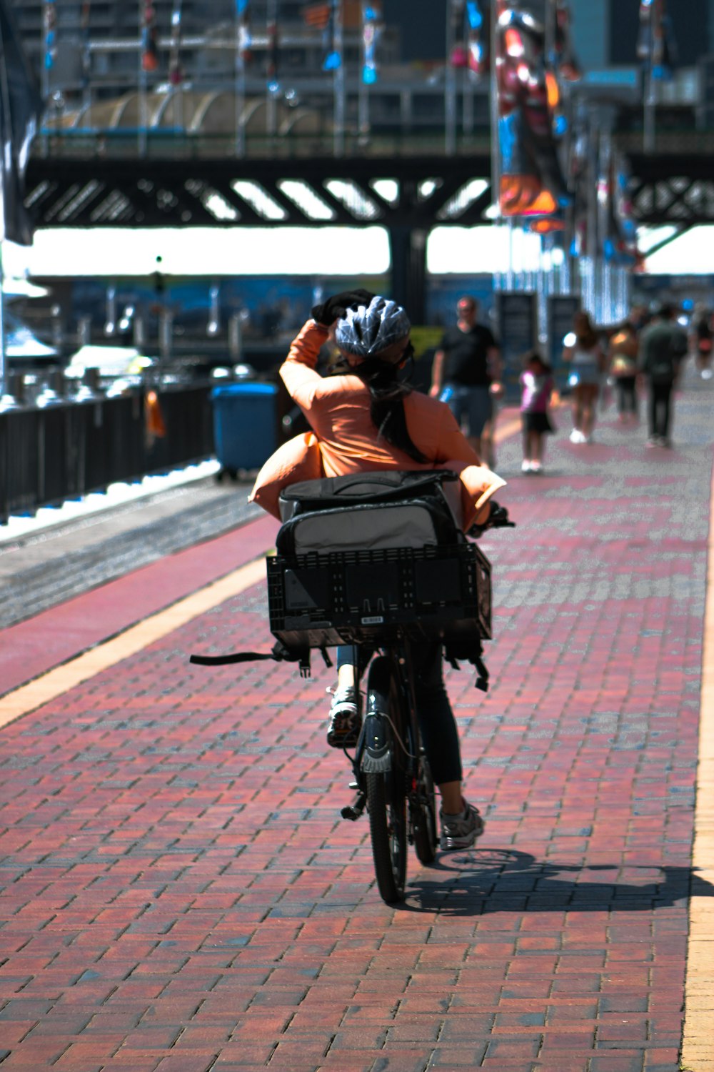 woman in black jacket riding on black bicycle on road during daytime