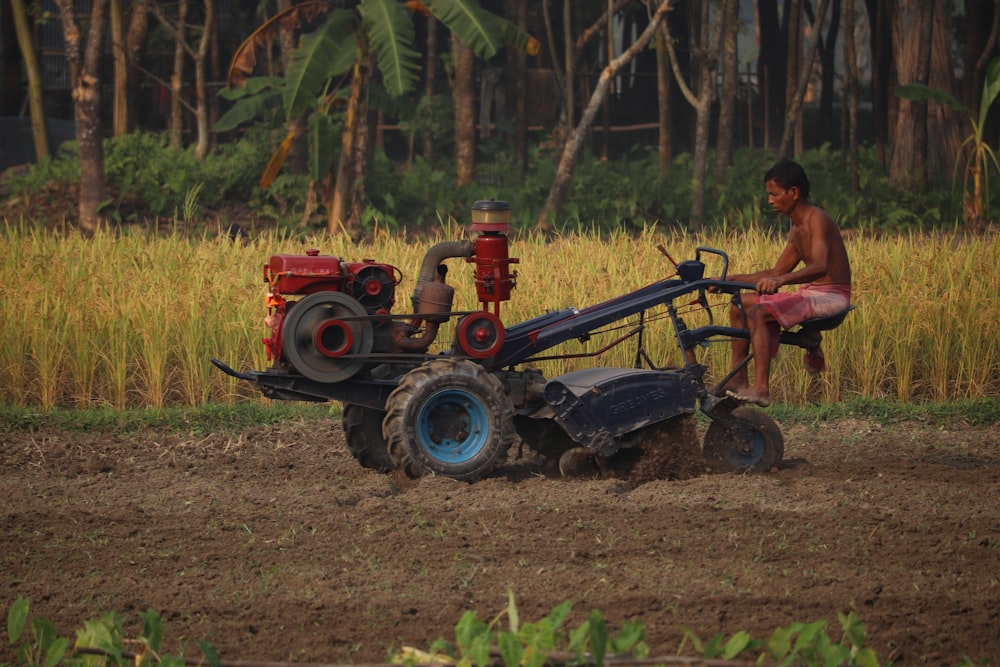 man in red t-shirt riding red tractor