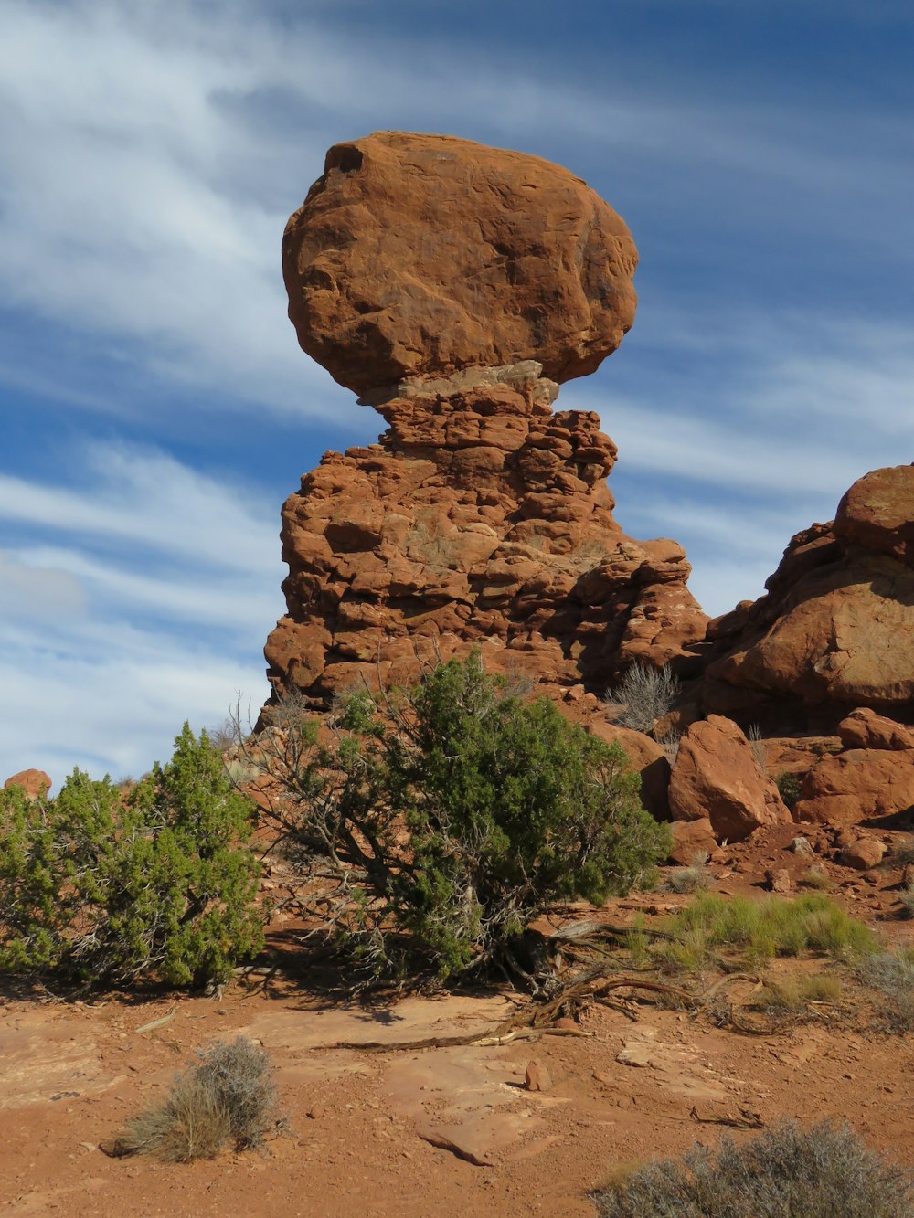 brown rock formation near green trees under blue sky during daytime