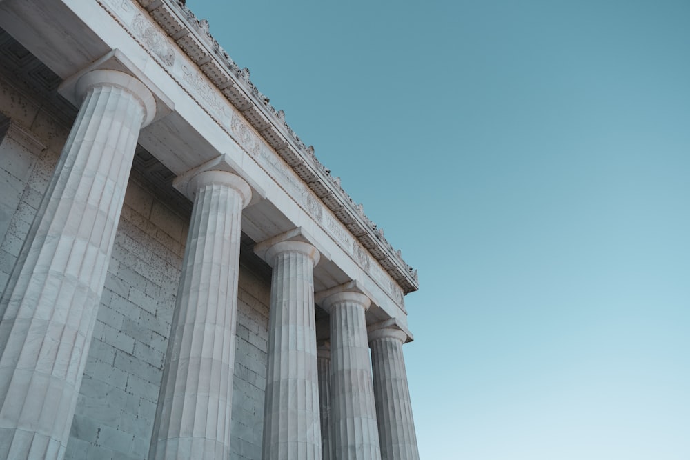 Weißes Betongebäude unter blauem Himmel tagsüber