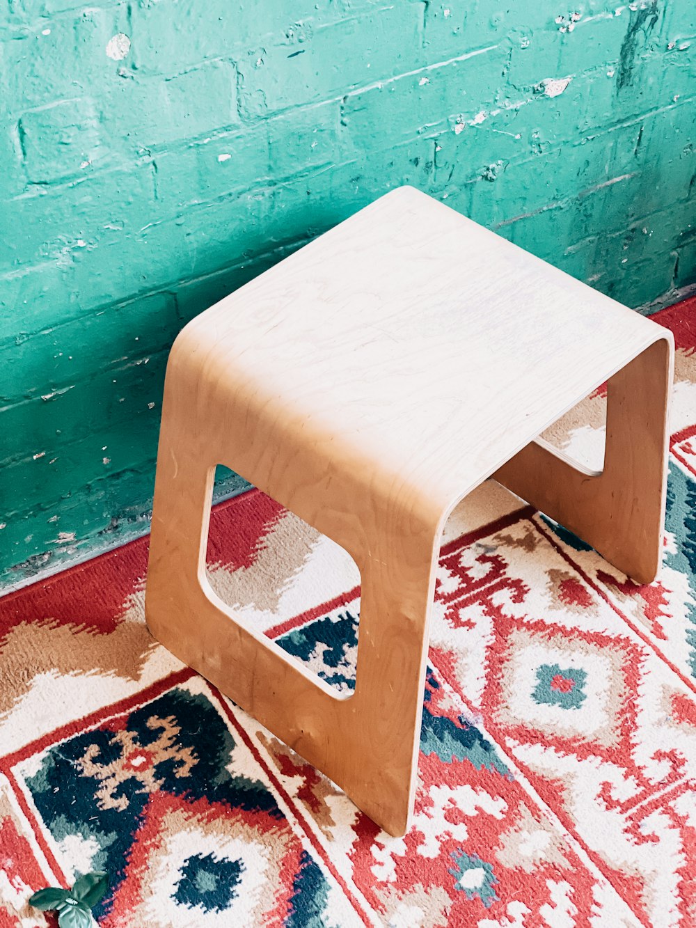 white wooden seat on brown and white floral area rug