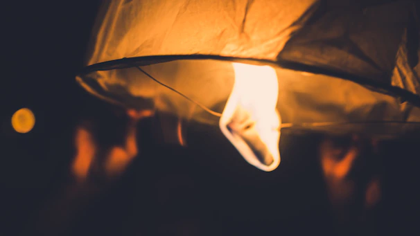 A softly glowing lantern casting a warm light over an open map filled with handwritten notes and pins.