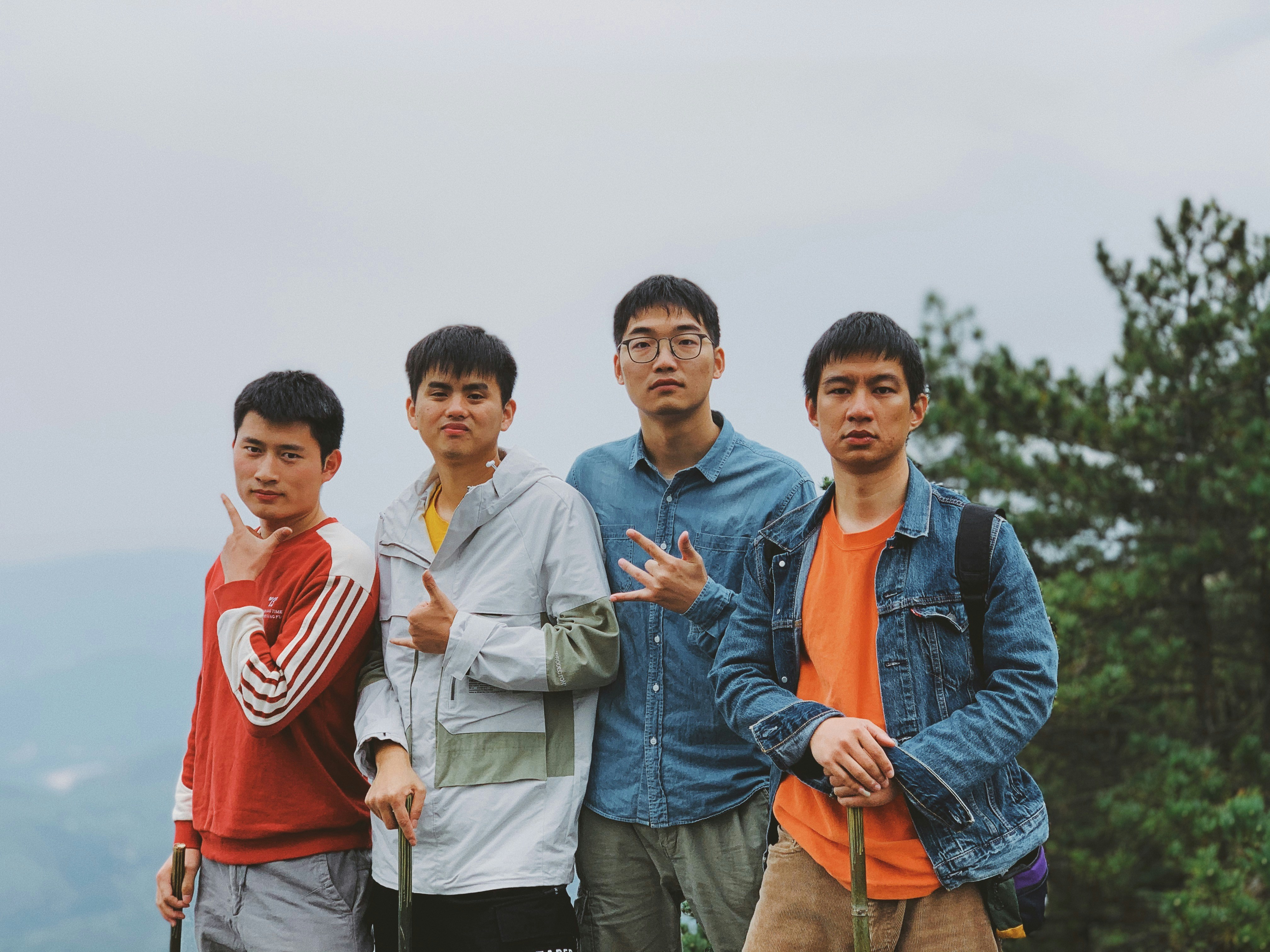 man in blue denim jacket standing beside man in red crew neck shirt