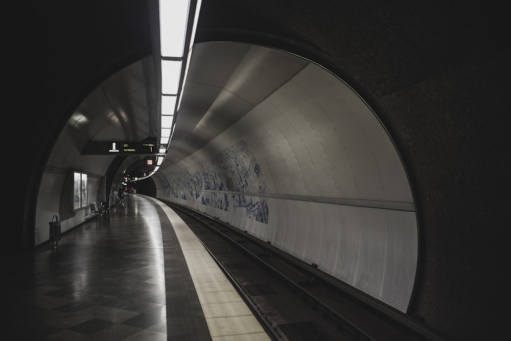 a subway station with a train coming out of the tunnel