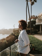 woman in white long sleeve shirt standing on green grass field during daytime