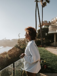 woman in white long sleeve shirt standing on green grass field during daytime