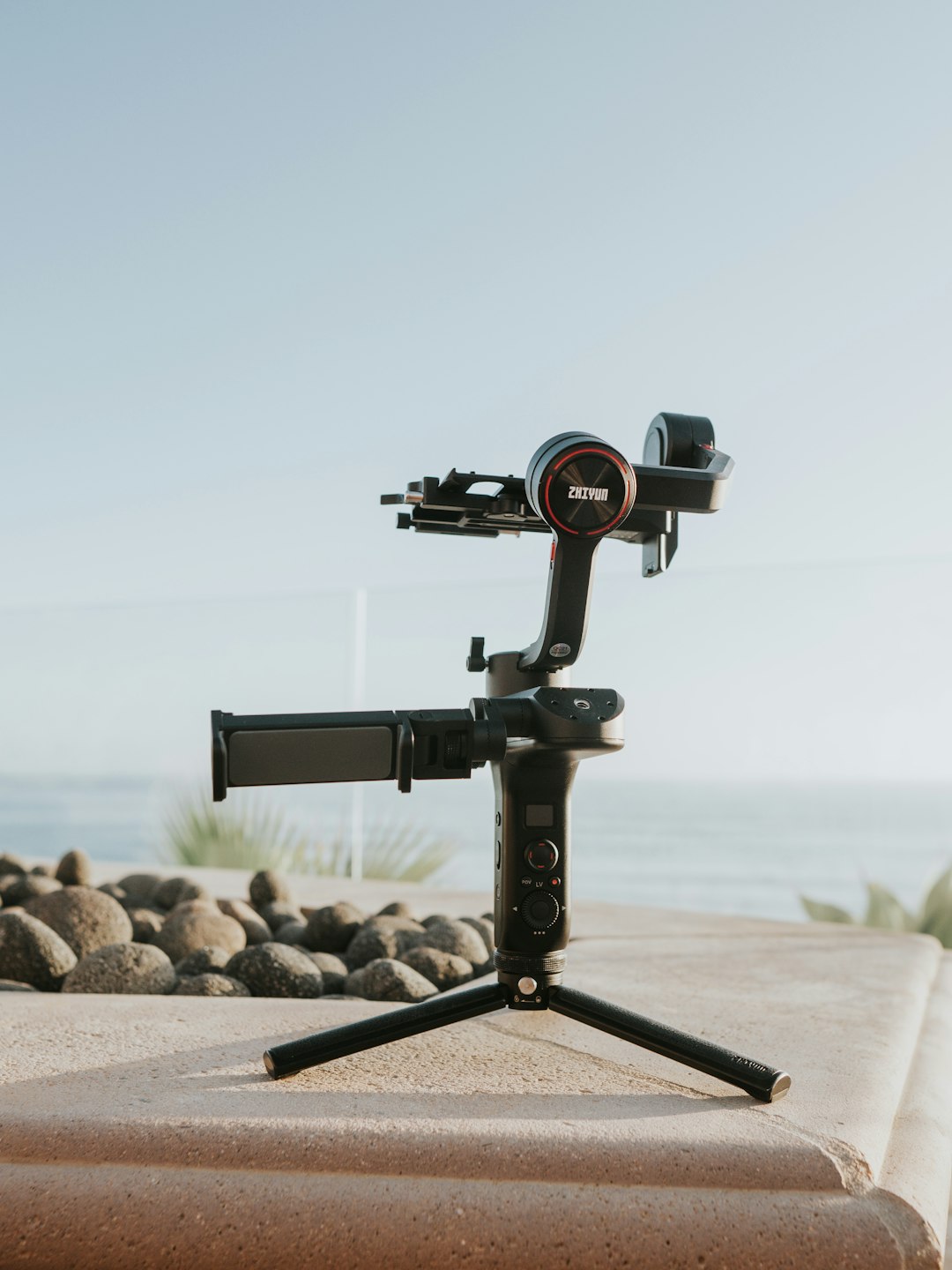 black camera on tripod on brown rock