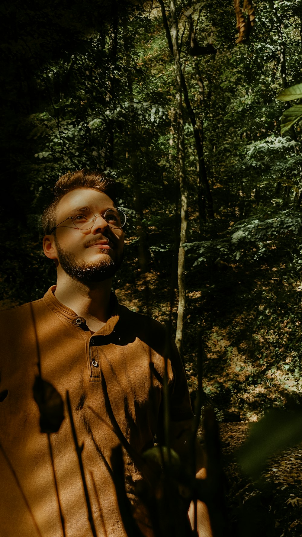 man in brown button up shirt wearing black framed eyeglasses