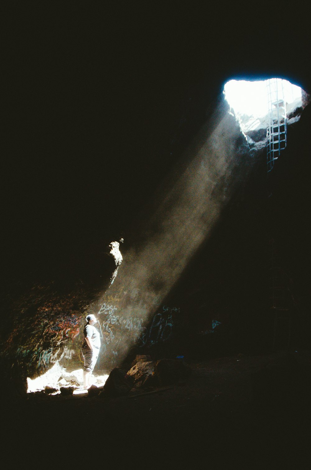 man in white shirt standing on rock