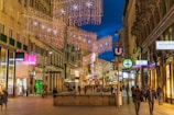A festive promotional banner hanging above a busy shopping area.