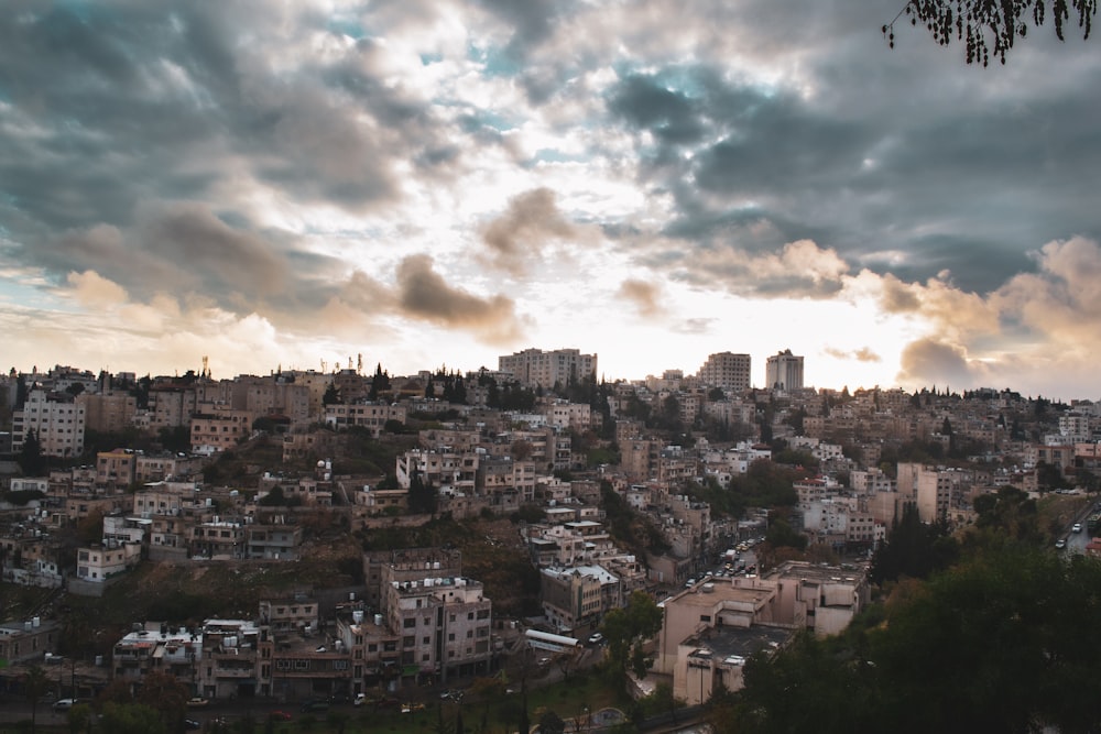 white and brown concrete buildings under white clouds during daytime